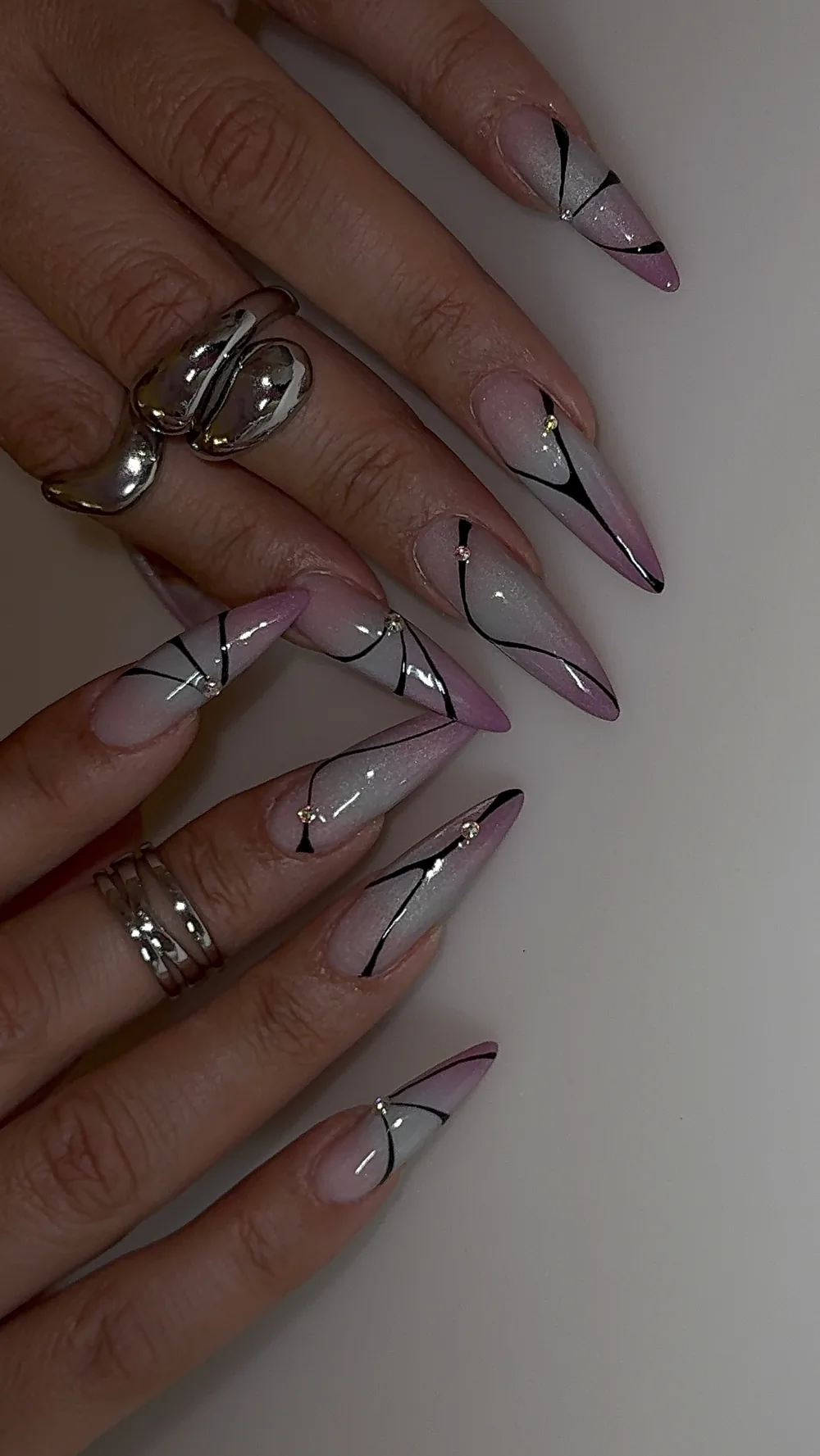 Long stiletto nails with pink ombre, black line art and crystals