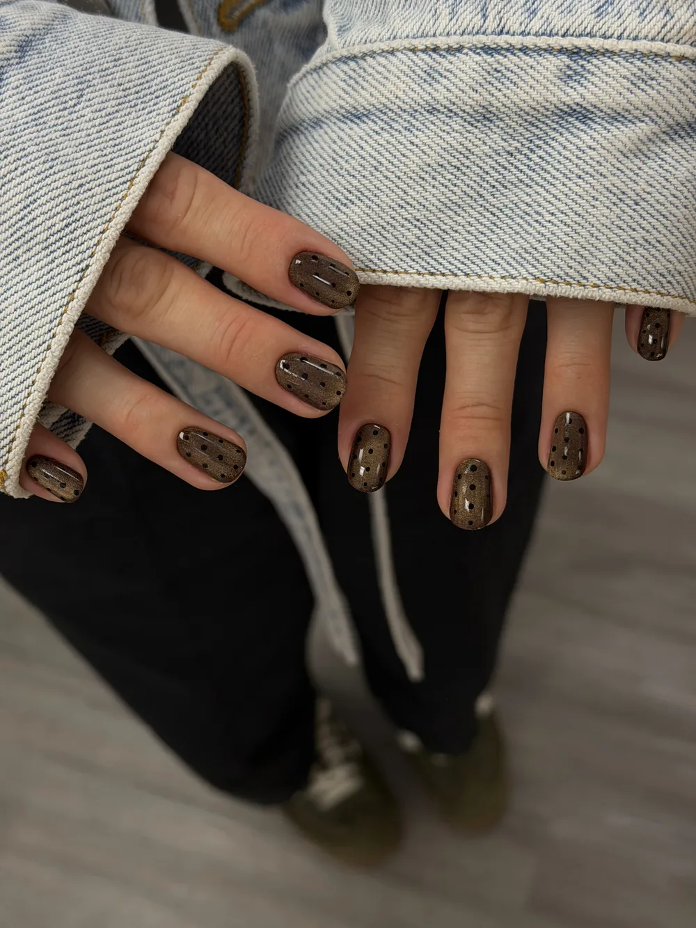 Dark glitter gel manicure styled with denim