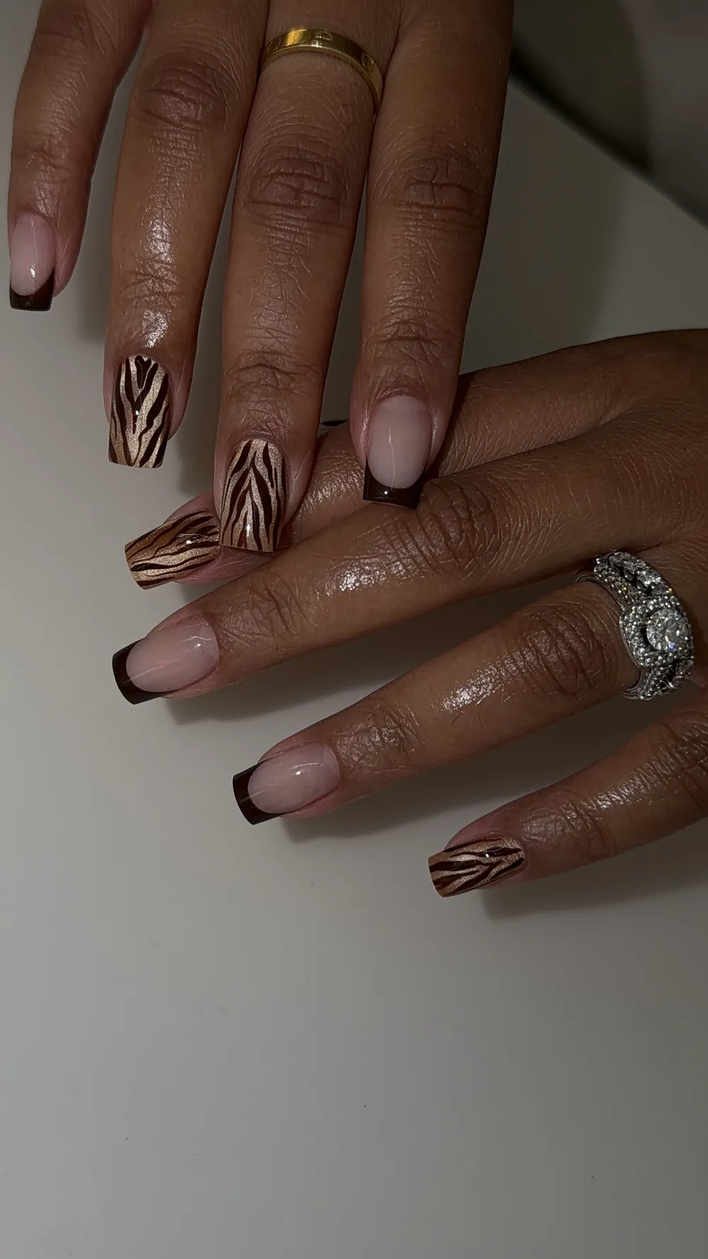 Chocolate brown French tips with gold zebra-print accent nails