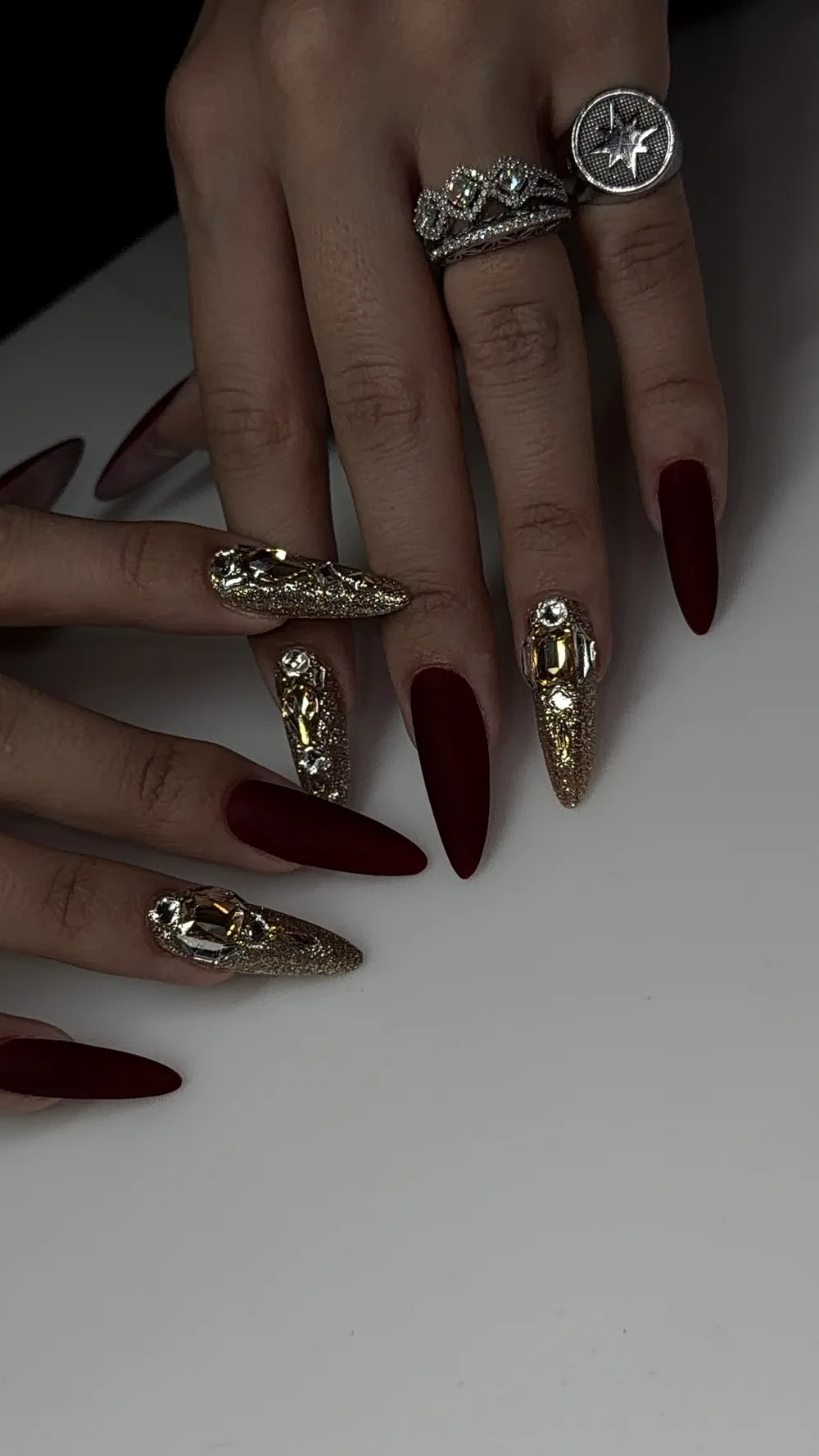 Matte deep red stiletto nails with gold crystal accent nails