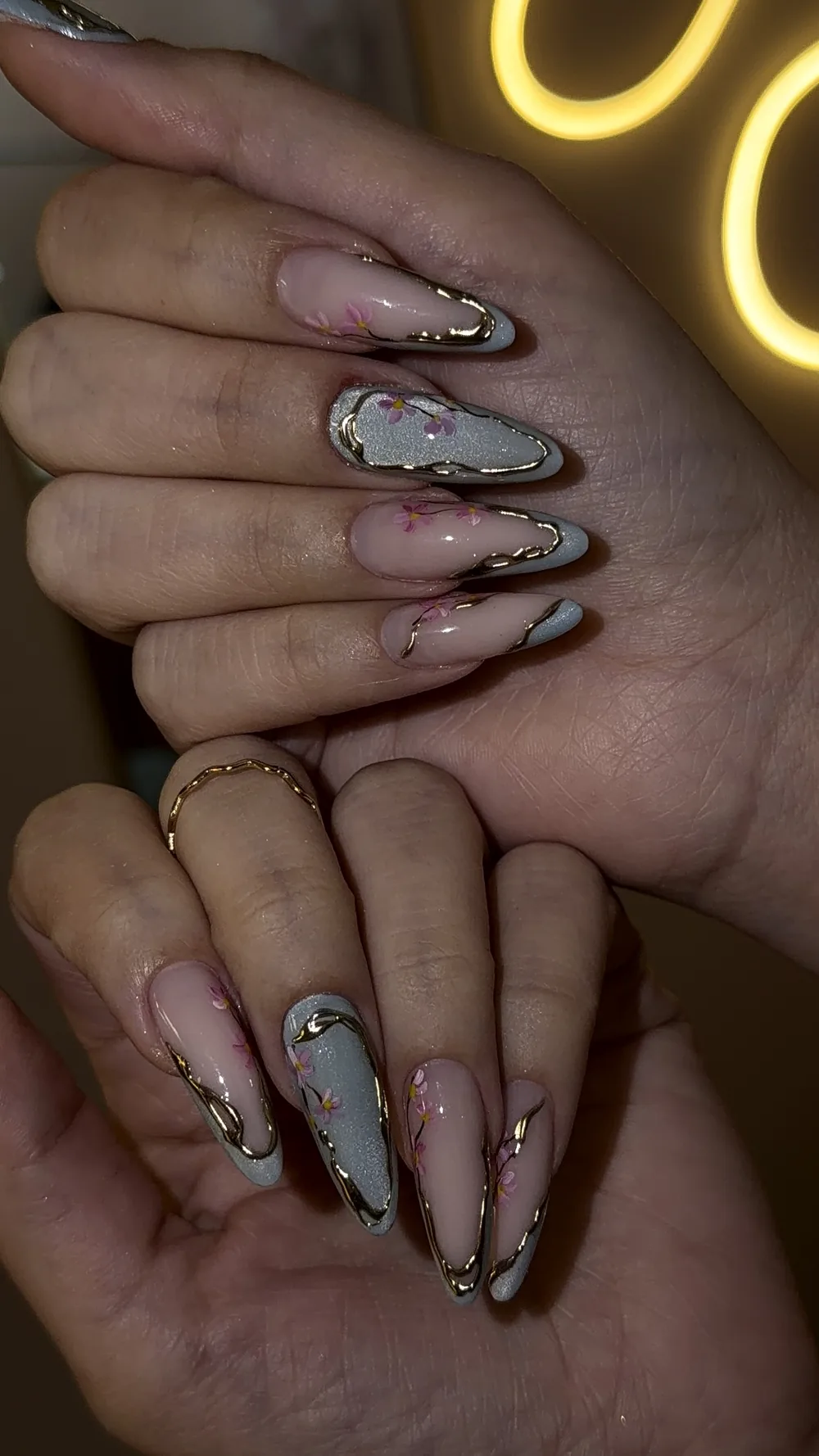 Cherry blossom nail art with gold chrome outlines on almond nails