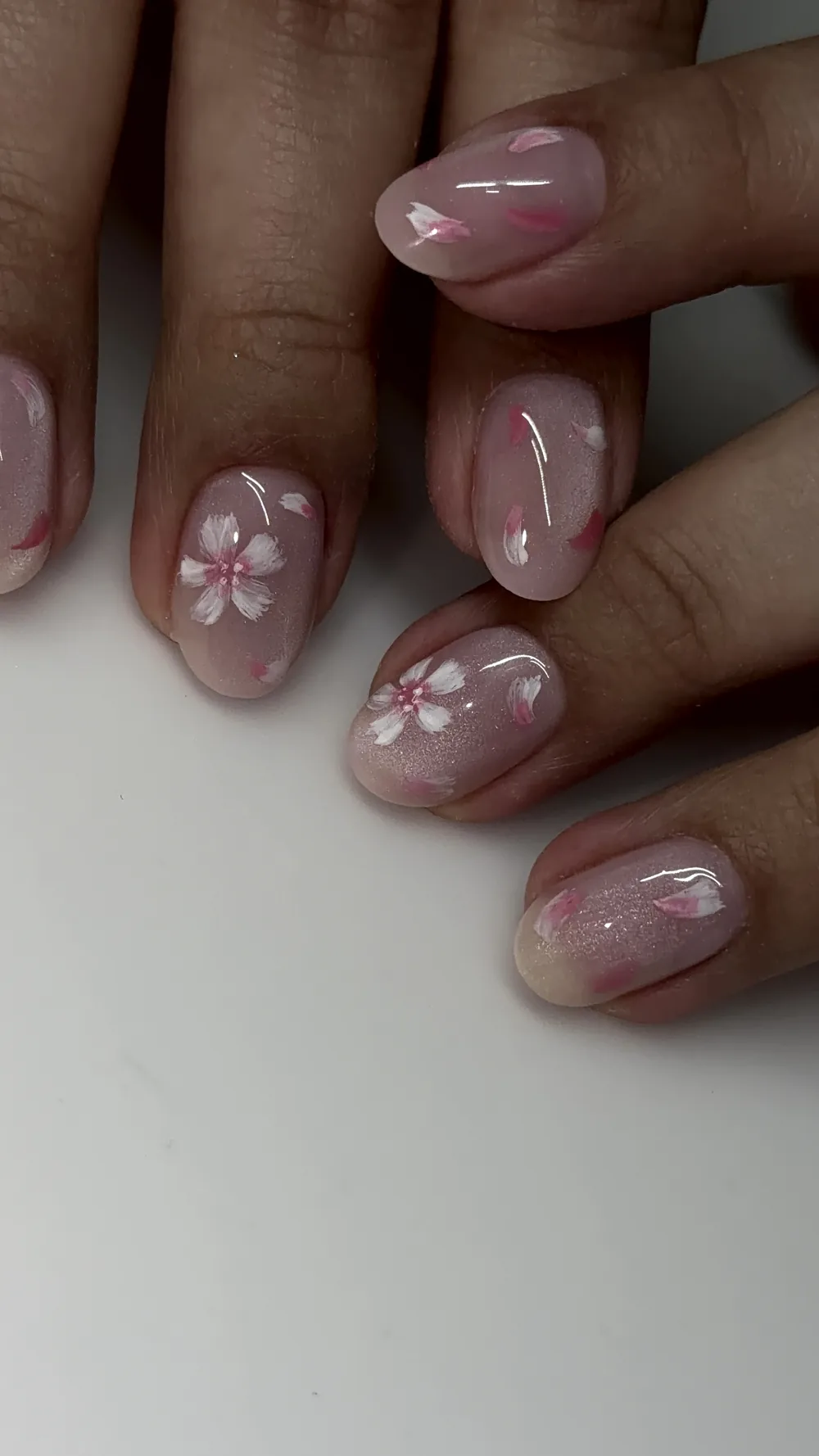 Short natural nails with hand-painted sakura blossoms