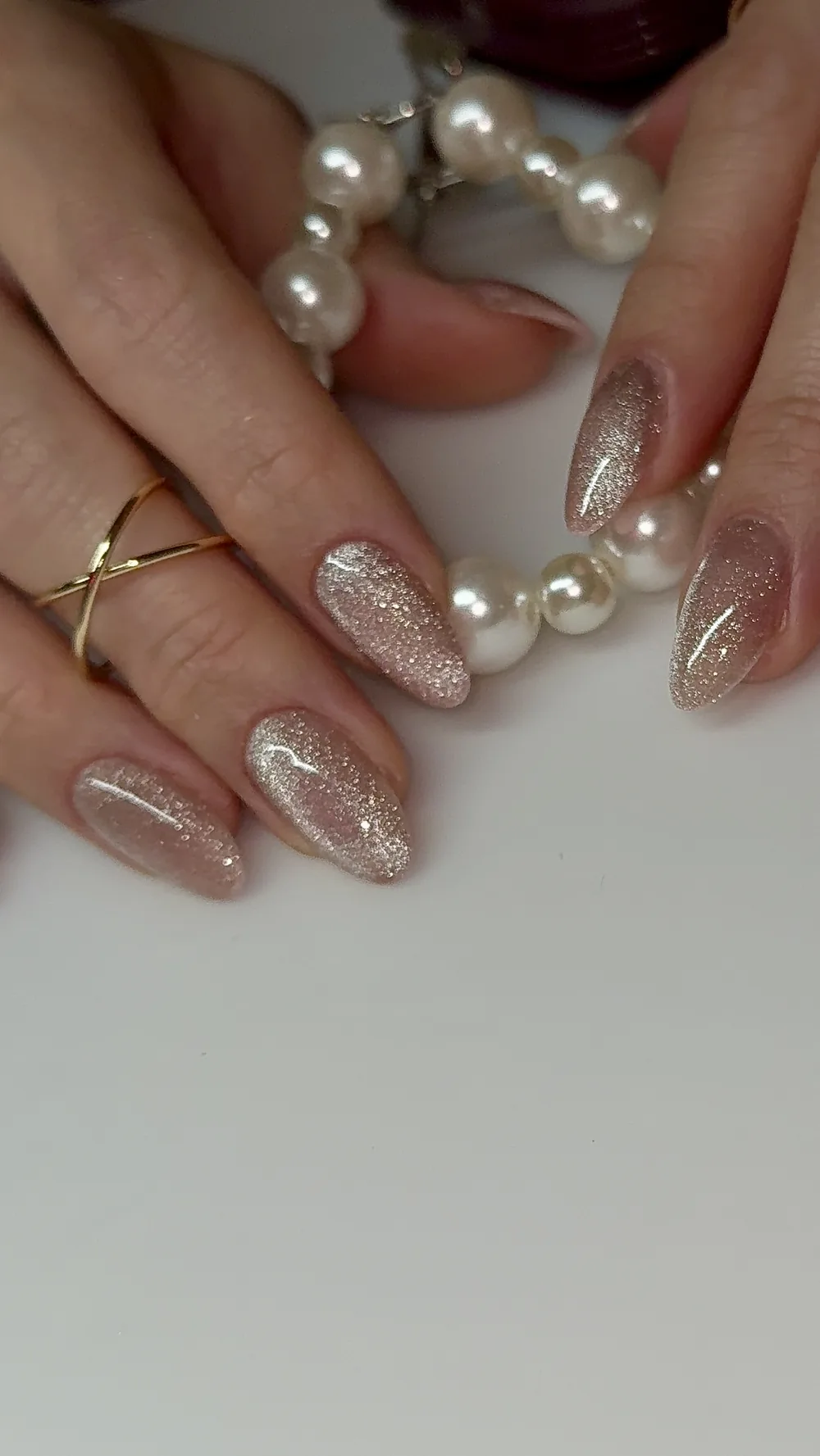 Rose gold glitter ombre almond nails styled with pearls