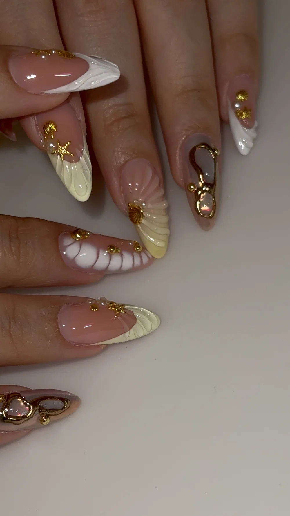 Seashell nail art in cream and white with gold starfish and pearls