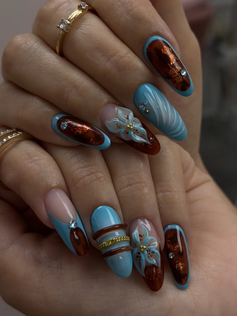 Sky blue and tortoiseshell nails with 3D floral accent
