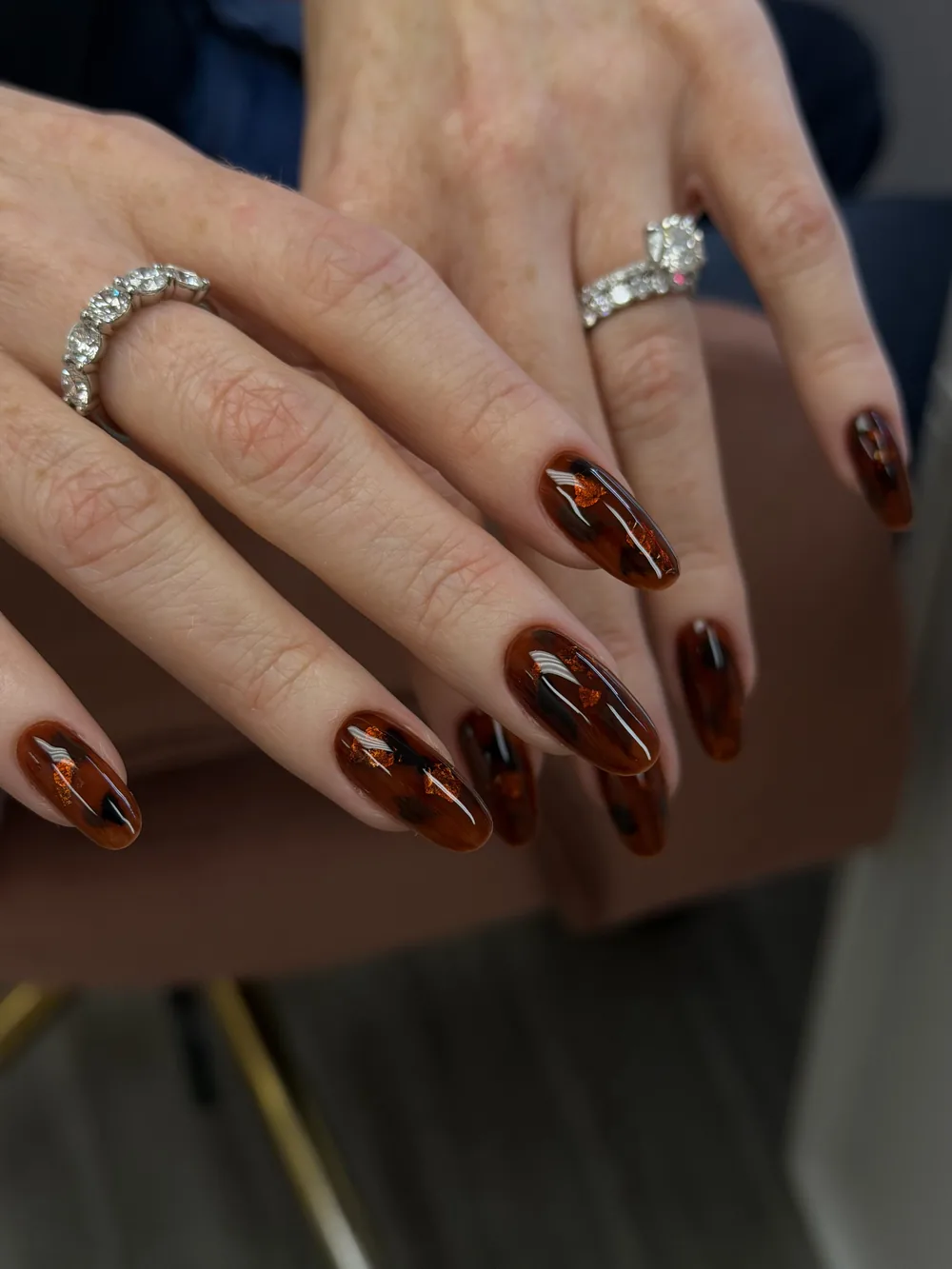 Amber tortoiseshell almond nails with a high-gloss finish